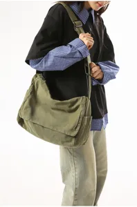 Detailansicht der olivgrünen Kuriertasche aus Segeltuch, die von einem Modell getragen wird