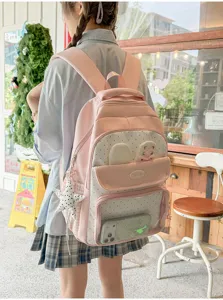 Vista posteriore di uno zaino scolastico rosa a pois con un grazioso design a orecchie di coniglio