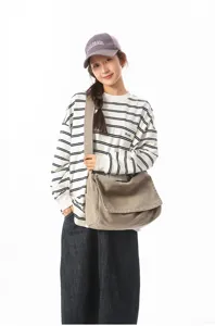 Asiatisches Model mit khakifarbenem Vintage-Canvas-Messenger-Bag im schlichten Design