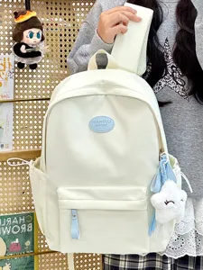 Detail eines cremefarbenen Rucksacks mit Plüschstern-Anhänger und Vordertasche