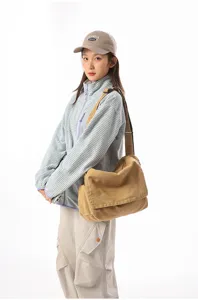 Asiatisches Model mit einer vintage khakifarbenen Canvas-Umhängetasche mit Klappe.