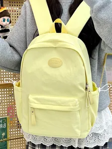 Detailansicht des gelben bonbonfarbenen Schulrucksacks mit Reißverschlusstasche.