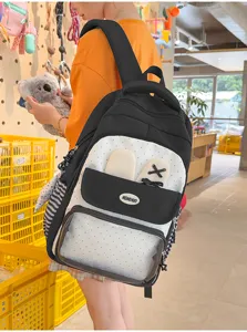 Ragazza che indossa un grazioso zaino ita-bag a pois bianco e nero con orecchie da coniglio.