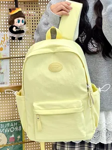 Detailansicht eines bonbonfarbenen hellgelben Schulrucksacks mit Vordertasche.