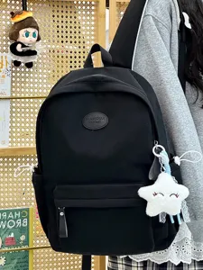 Detaillierte Ansicht eines schwarzen minimalistischen Schülerrucksacks mit Anhängern