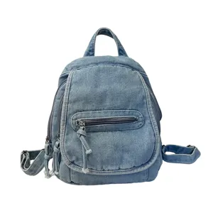 Detail view of the washed light blue denim texture on a vintage style ladies backpack