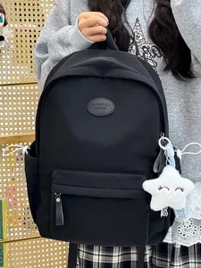 Detail eines schwarzen, minimalistischen Schülerrucksacks mit weißem Stern-Plüsch.