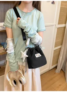 Borsa a secchiello nera con coulisse stile giapponese con ciondolo a stella su modella