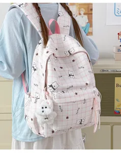 Detailed view of the cute pink plaid cartoon bear backpack worn by a student