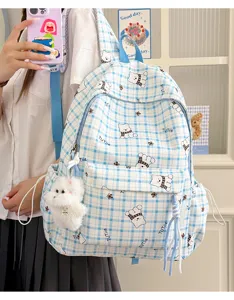 Close-up of cute blue plaid school backpack with cartoon bears and plush charm