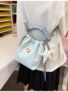 Primo piano di una borsa a secchiello giapponese celeste con ciondolo a stella e manico