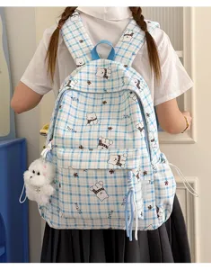 Back view of blue plaid backpack with cute cartoon bear pattern and plush charm