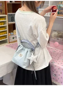 Dettaglio di una graziosa borsa a secchiello celeste con ciondolo a stella e manico Lucky.