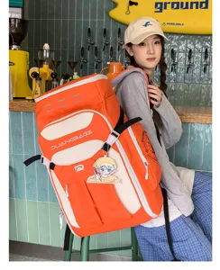 Asiatin trägt einen großen orange-beigen Wanderrucksack mit Farblock-Design im Café.