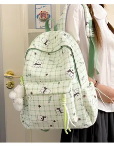 Lifestyle view of a green checkered student backpack with cute cartoon bear prints.