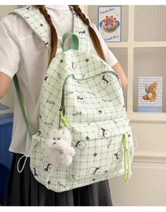 Back view of a green grid school backpack featuring bear prints and a puppy charm