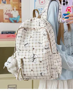 Detailed view of cute plaid backpack featuring cartoon bear patterns and plush charm