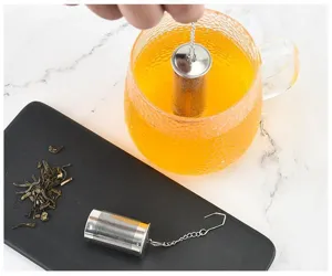 Vue detaillee de l'infuseur a thé en acier inoxydable avec chaine dans une tasse.
