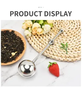Primer plano del infusor de té de acero inoxidable con mecanismo de empuje y filtro de bola.
