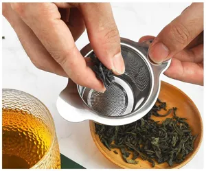 Stainless steel tea strainer detail showing fine mesh filtering loose tea leaves.