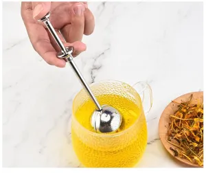 Detalle de infusor de té de acero inoxidable con mango telescópico y malla fina.