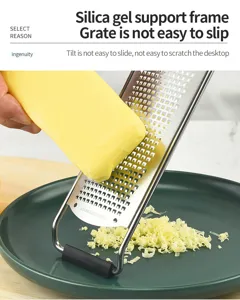Stainless steel cheese grater detail, non-slip silicone support frame for safe kitchen use.