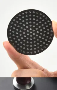 Nahaufnahme des Edelstahl-Espresso-Puck-Screens mit Mikro-Löchern für gleichmäßigen Wasserfluss.
