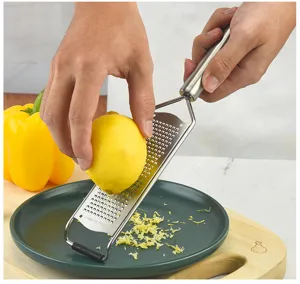 Vue détaillée de la râpe à citron en inox montrant les mains râpant le fromage aisément.