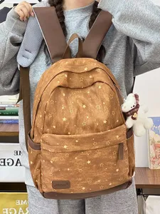 Detailansicht des braunen Rucksacks mit Sternenmuster und weißem Bärenanhänger