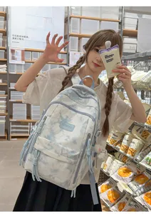 Teen girl wearing a blue and white tie-dye backpack in a lifestyle store setting