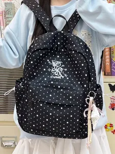 Detail eines schwarzen Rucksacks im College-Stil mit weißen Sternen und Pünktchen für Mädchen