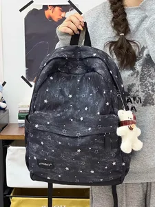 Detailansicht eines schwarzen Vintage-Rucksacks mit Sternmuster und einem weißen Bären-Anhänger