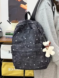 Nahaufnahme eines Vintage-Rucksacks mit Sternenmuster und süßem Bären-Schlüsselanhänger