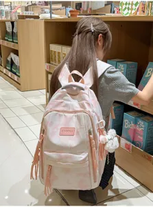 Detailed view of pink tie-dye backpack with multiple layers and fluffy pendant detail