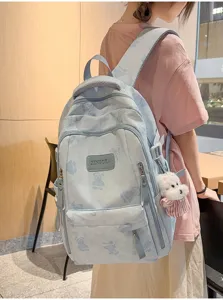 Side view of a blue bear print school backpack featuring multiple storage pockets.