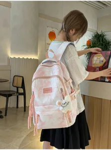 Student tie-dye pink backpack with cute plush doll in cafe setting