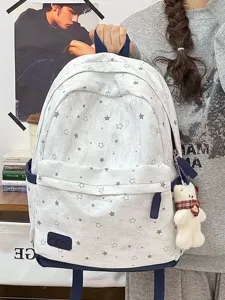 Detailansicht eines grauen Rucksacks mit Sternenmuster und einem süßen Bärenanhänger