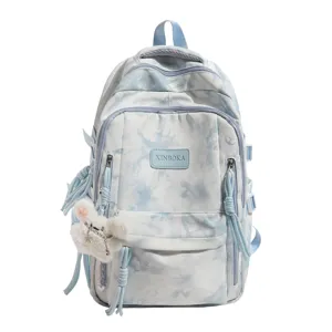 Front view of blue tie-dye fashion backpack with a cute plush bunny keychain