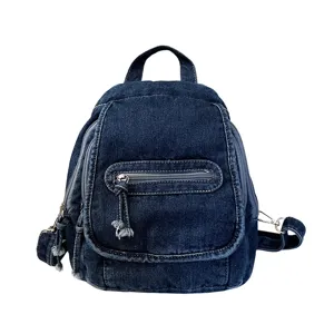 Front view of a retro washed blue denim backpack with zipper details and fringe accents.