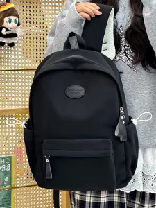 Schwarzer minimalistischer Rucksack für Schüler mit geprägtem Logo-Patch.