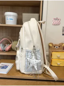 Vista laterale dettagliata di uno zaino scolastico bianco a pois per ragazze
