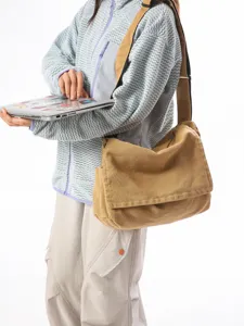 Lässige khakifarbene Canvas-Umhängetasche mit großer Klappe, am Modell für den Alltag