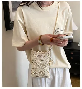 Détail d'un sac à téléphone en crochet fait main porté en bandoulière par un mannequin