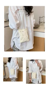 Detail view of a cream hand-knitted crochet crossbody bag for mobile phones