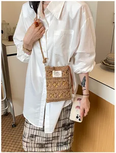 Gros plan d'un sac à bandoulière en tricot fait main pour téléphone portable, jaune gingembre