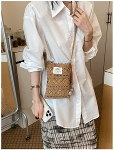 Gros plan d'un sac à bandoulière marron tricoté à la main porté sur une chemise.