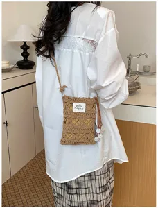 Handmade knitted hollow crossbody phone bag shown being worn in a stylish setting