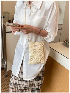 Handmade crochet phone bag for women with hollow-out knit pattern and crossbody strap.
