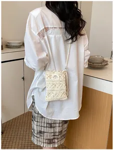 Artistic handmade crochet phone bag on a model in a minimalist kitchen setting