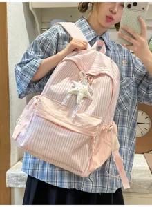 Asiatisches Model im Selfie mit dem rosa gestreiften Rucksack und Sternanhänger.